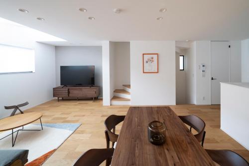a living room with a wooden table and a television at LIRI 葵 3min to JR弁天町 Direct to USJ & Umeda & EXPO in Osaka