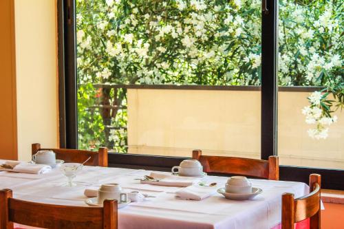 einen Tisch mit einem weißen Tischtuch und einem großen Fenster in der Unterkunft Hotel Holiday in San Benedetto del Tronto
