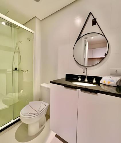 a bathroom with a toilet and a sink and a mirror at #The RED# C/PiSciNa, Ar Cond & Garagem in Curitiba