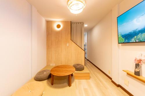 a living room with a table and two stools at BentenHaus in Osaka