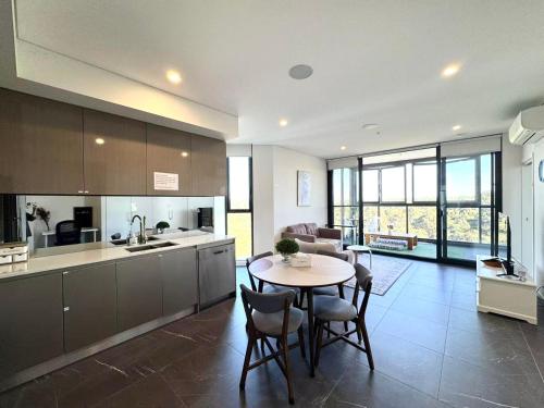 a kitchen and living room with a table and chairs at Serene Parkside Retreat 2Brs@ close 2 Olympic park in Sydney