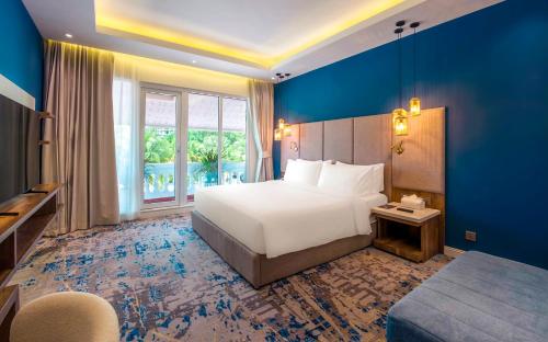 a hotel room with a large bed and a window at Queenco Hotel & Casino in Sihanoukville