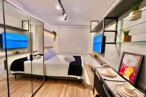 a bedroom with a bed and a desk in a room at Fantastico, Studio Condo Club in Curitiba