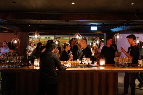 a group of people standing at a bar at Hotel Indigo Brisbane City Centre by IHG in Brisbane