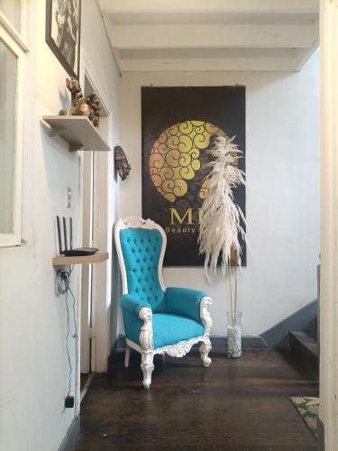 a blue chair in a hallway with a painting at Casona Turística Gonzales in Lima
