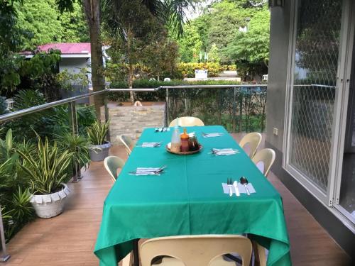 a table with a green table cloth on a balcony at Camiguin Lanzones Resort in Mambajao