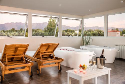 a bathroom with two chairs and a tub and windows at Villa Mansa in Vistalba