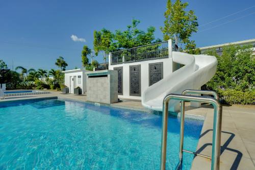 a slide in a swimming pool next to a house at The Mansion Boutique Hotel in Mabalacat