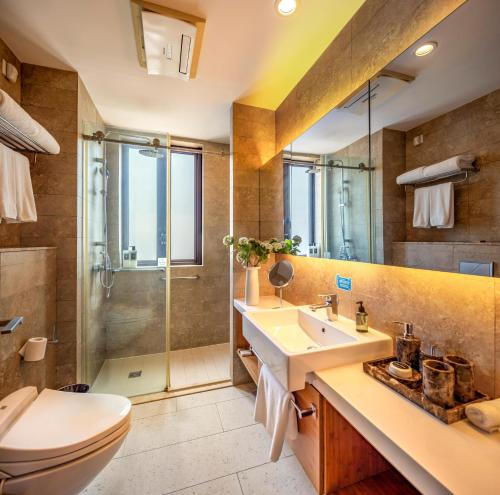 a bathroom with a toilet and a sink and a shower at Green Court Premier Jinqiao Shanghai in Shanghai
