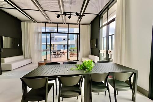 una sala da pranzo con tavolo e sedie neri di AMÁVEl, Studio com Ar Condicionado e Tv Smart a Curitiba