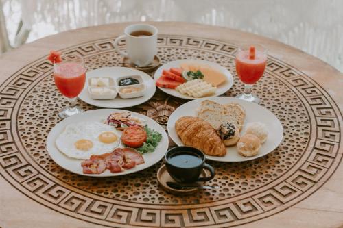 a table topped with plates of breakfast foods and drinks at Villa Kapungkur in Jimbaran