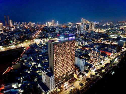 um grande edifício numa cidade à noite em Wink Icon Hotel Danang Riverside - Luxury Suites - 24hrs Stay & Rooftop Pool Bar em Da Nang