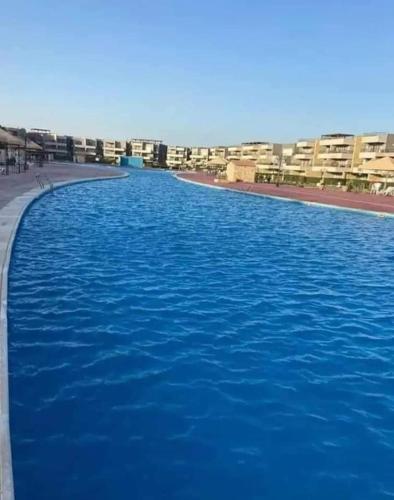 a large pool of blue water in front of a building at بيت الروبي in Ain Sokhna