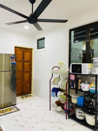 a kitchen with a ceiling fan and a shelf with dishes at EM Rumah Inap SueKori Jeli in Jeli