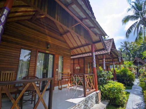 a wooden house with a porch and a balcony at Dangin Kubu in Toyapakeh