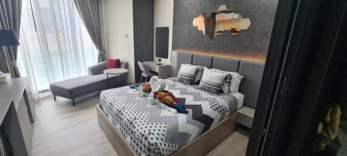 a small bedroom with a bed and a chair at The Edge Central Pattaya - Unique & Luxurious in Pattaya Central
