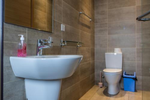 a bathroom with a sink and a toilet at CasaNova Airport Suites in Accra