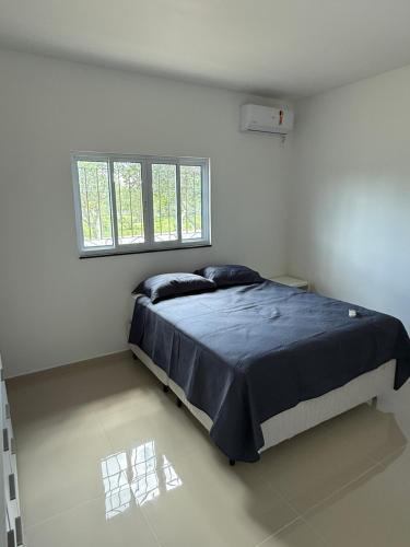 ein Schlafzimmer mit einem Bett in einem weißen Raum in der Unterkunft Malicia Ranch in Lagoa do Boi