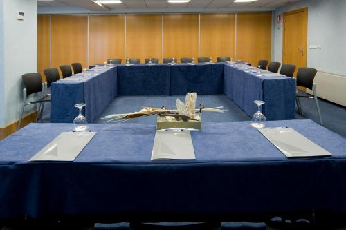 a conference room with a blue table and chairs at Apartamentos Jauregui in Hondarribia