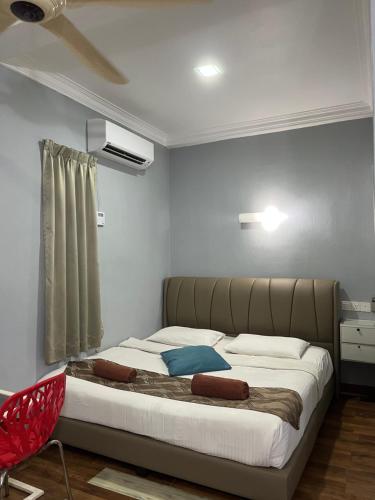 a large bed in a room with a red chair at White Lodge in Pantai Cenang
