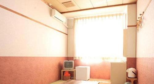a room with a window and a tv in it at Hotel SP Haruno in Kochi