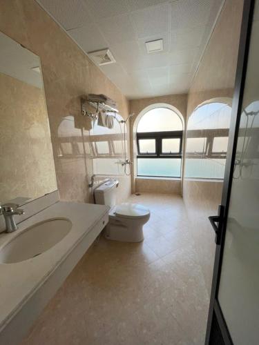 a bathroom with a sink and a toilet and a window at New Sun Hotel in Ha Long