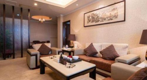a living room with a couch and a table at Quanzhou Royal Prince Hotel in Quanzhou