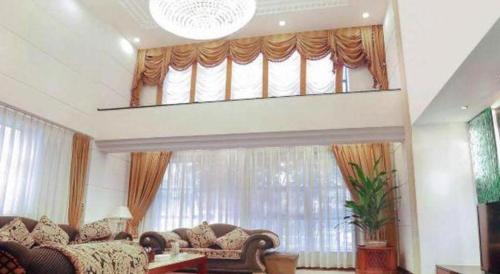 a living room with couches and a large window at Quanzhou Royal Prince Hotel in Quanzhou