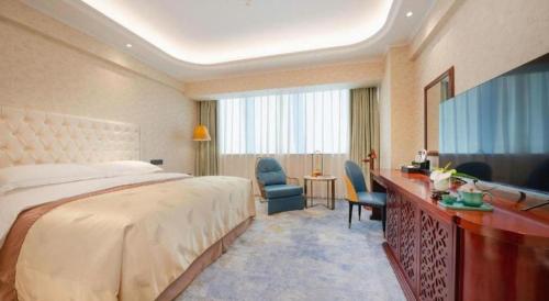 a hotel room with a large bed and a desk at Jiaxing Sunshine Hotel in Jiaxing
