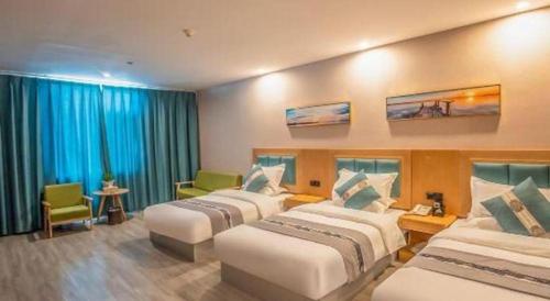 a hotel room with four beds in a room at Lijiang Waika Hotel in Lijiang