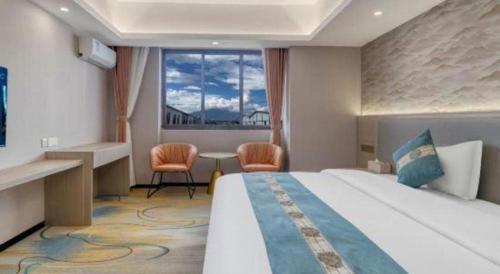 a hotel room with a large bed and a window at Lijiang Waika Hotel in Lijiang