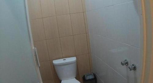 a bathroom with a white toilet and a shower at Griya Jogja Hotel in Yogyakarta