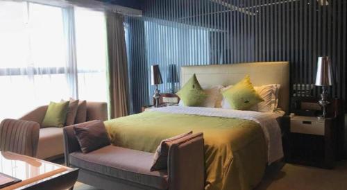 a bedroom with a large bed and a couch at Yongzhou Chuang Fa Cheng XiaoXiangYi Hotel in Guzhuting