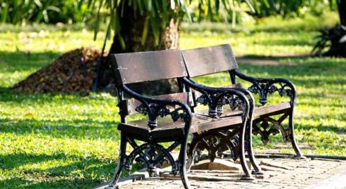 a park bench sitting on a sidewalk in a park at JIAN AI XI YUE HOTEL in Yiwu