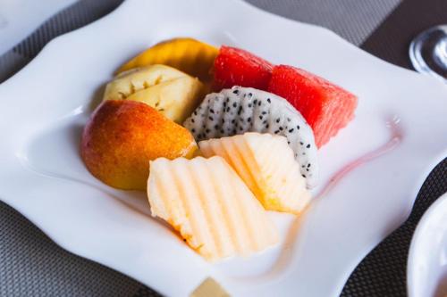 a plate of fruit on a white plate at Palace Suite Residence in Phnom Penh