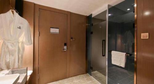 a bathroom with a shower and a glass door at East Queen Hotel (Xi'an Beimen Metro Station) in Xi'an