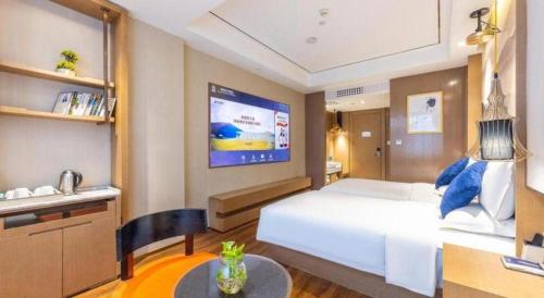 a bedroom with a large white bed and a tv at East Queen Hotel (Xi'an Beimen Metro Station) in Xi'an