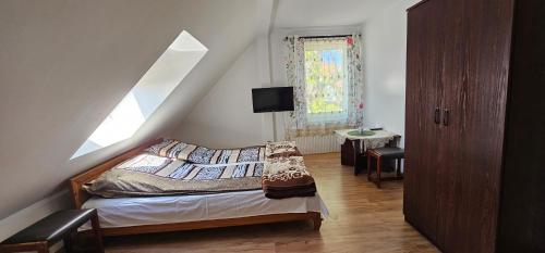 a bedroom with a bed and a staircase with a window at Pokoje U Wandy in Łeba