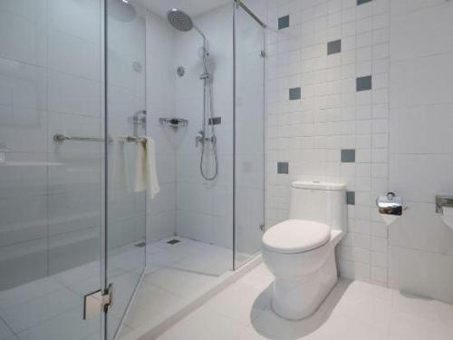 a white bathroom with a shower and a toilet at Magnotel Hotel Jining Yanzhou Metro Station Jiuxianqiao South Road in Jining