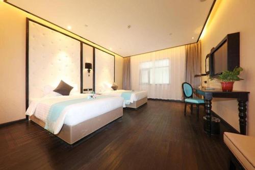 a hotel room with two beds and a desk at Xana Hotelle·Tianshui Shangyi Plaza in Tianshui