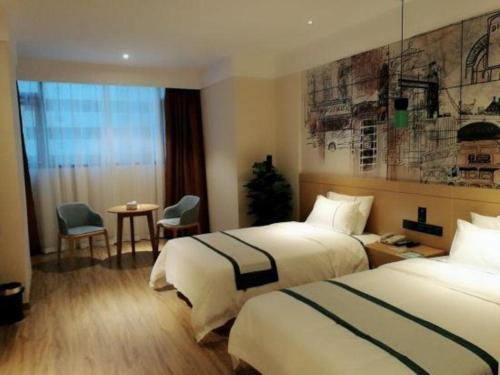 a hotel room with two beds and a table at Echarm Hotel Changsha High-speed Railway Station in Changsha