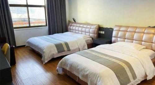 a hotel room with two beds and a window at Shell Linzhi Bayi Area G318 Shuangyong Road Hotel in Nyingchi