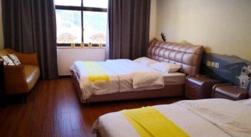 a hotel room with two beds and a couch at Shell Linzhi Bayi Area G318 Shuangyong Road Hotel in Nyingchi