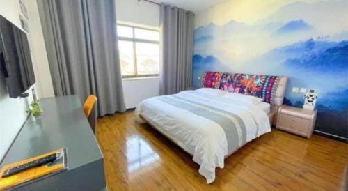 a bedroom with a bed with a painting on the wall at Shell Linzhi Bayi Area G318 Shuangyong Road Hotel in Nyingchi