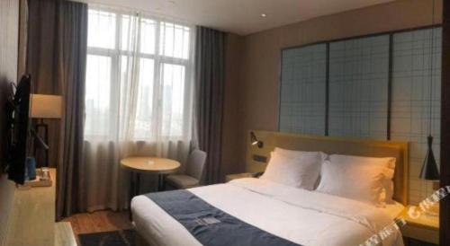 a hotel room with a bed and a window at Echarm Hotel Changde Taoyuan Walking Street Jinyuan Tower in Changde
