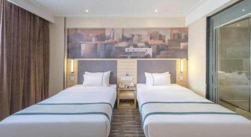 a row of three beds in a hotel room at City Comfort Inn Liuzhou The Mixc Xijiang Road in Liuzhou