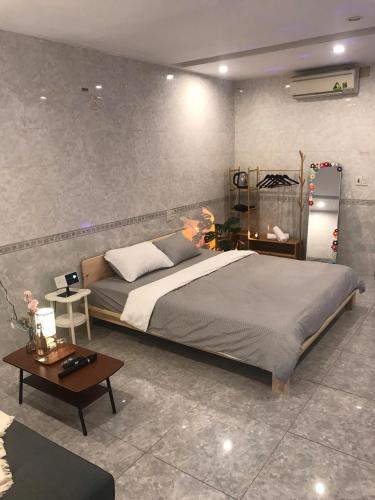 a bedroom with a large bed and a table at DU Home Huế in Thôn An Hòa