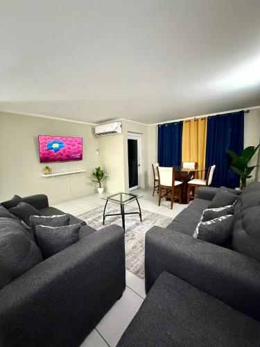 a living room with two couches and a dining room at Central 2BDR Stay in Kupuis