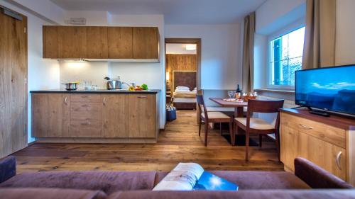 a kitchen and living room with a table and a television at Residence St Konstantin in Fiè