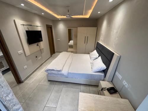 比姆塔尔The grand inn lake side的一间带床和平板电视的卧室